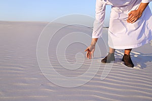 Muslim man develops sand along wind and standing in middle of de