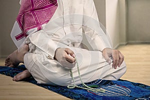 Muslim man dhikr with beads at home photo