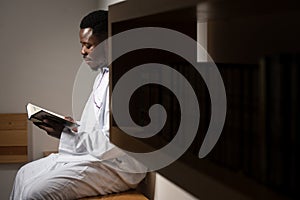 Muslim Man In Dishdasha Is Reading The Quran