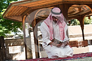 Muslim Man In Dishdasha Is Reading The Quran