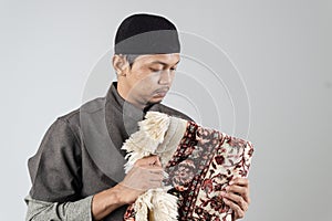 a Muslim man dressed in a kurta suit and wearing a black cap
