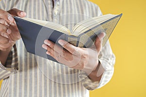 muslim man hand holding Holy book Quran with copy space