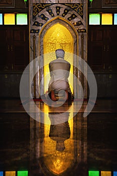 Muslim man having worship and praying in islam ceremony in mosque photo