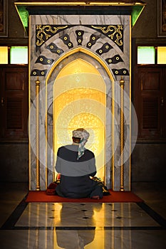 Muslim man having worship and praying in islam ceremony in mosque photo