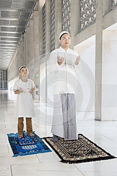 Muslim man with his son prays to GOD