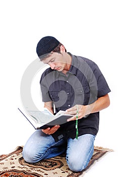 Muslim man is holding holly book Qoran and praying
