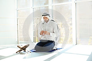 Muslim man with Koran praying