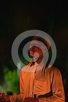 A Muslim man lighten up the campsite with the fire torch in his hands