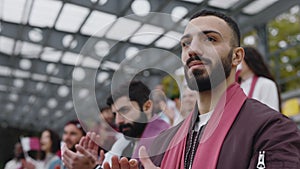 Muslim man listening anthem and applauding on soccer match