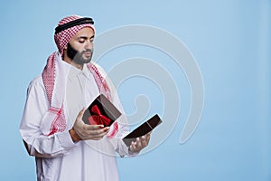 Muslim man opening gift box