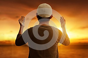 Muslim man praying at sunset