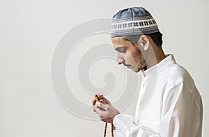 Muslim man praying with tasbih during Ramadan photo