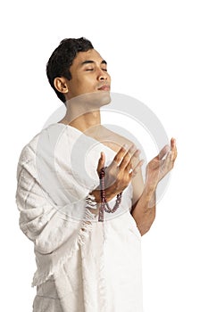 Muslim man praying wearing ihram isolated