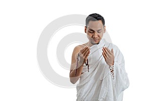 Muslim man praying in white traditional clothes