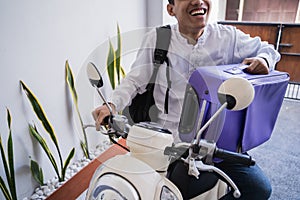 Muslim man ride motorcycle for idul fitri balik kampung mudik carrying suitcase