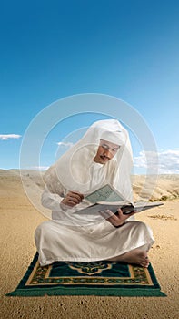 Muslim man sitting and reading the Quran on the prayer rug