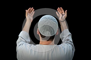 Muslim man standing and praying in the front of Kaaba in Mecca