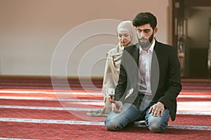 Muslim man and woman praying in mosque