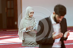 Muslim man and woman praying in mosque