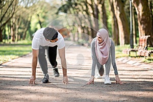 Muslim man and woman in starting position preparing for run