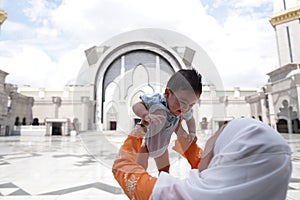 Muslim mother and her son together at a mosque