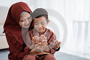 Muslim mother and son praying together