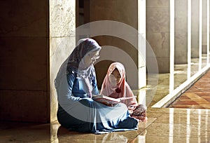 Muslim mother teach her daughter reading koran