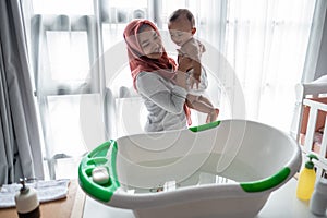 Muslim Mother washing little boy in bathtub