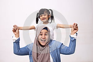 Muslim mother wearing hijab smiling while playing with her baby girl, mom and daughter love each other