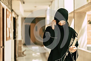 Muslim niqab woman read and learning the Quran and faith The Holy Al Quran book. Arab saudi black chador lady