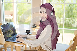 Muslim operator woman in headset using computer answering customer call in office, Customer service concept