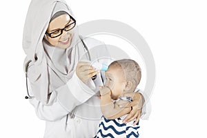 Muslim pediatrician checking her patient