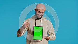 Muslim person holding tablet with greenscreen template