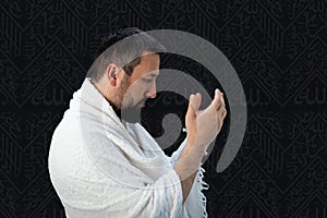 Muslim pilgrims in white traditional clothes, praying at Kaaba in Makkah photo