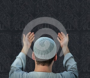 Muslim pilgrims in white traditional clothes, praying at Kaaba in Makkah photo