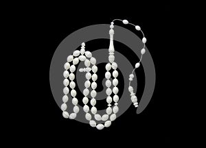 Muslim prayer beads made from white catalin. Isolated on black background.