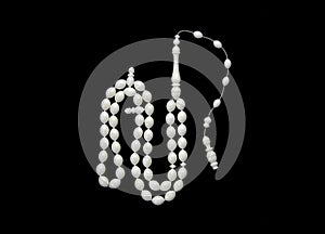 Muslim prayer beads made from white catalin. Isolated on black background. photo