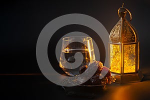 Muslim religious tradition, holy month of Ramadan, Islam and Iftar concept theme with a bowl of dates, prayer beads, glass of photo