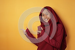 Muslim Teenage Girl Smiling and  Pointing to The Side With Copy Space