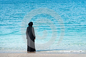 Muslim woman in abaya by the seaside