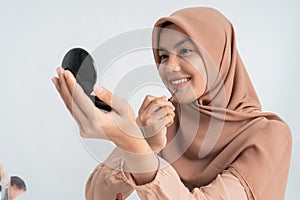 Muslim woman applying make up