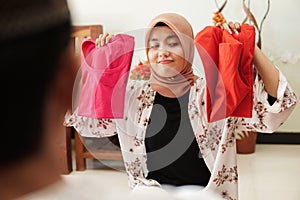 Muslim woman confuse choosing between two clothes