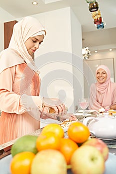 Muslim woman cooking food with friend at home
