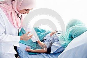 Muslim woman doctor to be injected arm patient