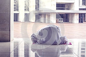 Muslim woman doing prostration gesture in mosque