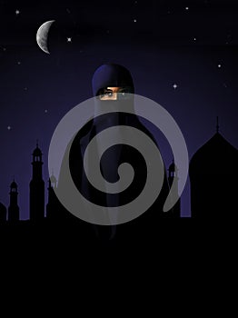 A muslim woman dressed in a niqab is seen in front of a mosque and minarets at night
