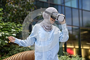 Muslim woman experiencing virtual reality outdoors