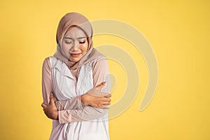 muslim woman feeling cold with both hands hugging her body