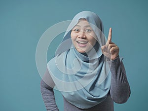 Muslim Woman Having Bright Idea, Looking at Camera Smiling and Pointing Up