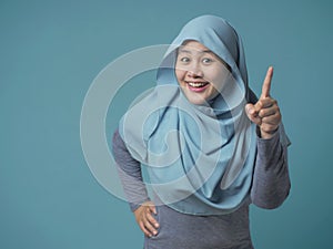 Muslim Woman Having Bright Idea, Looking at Camera Smiling and Pointing Up